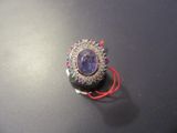 a picture of a broochle with a purple stone in it
