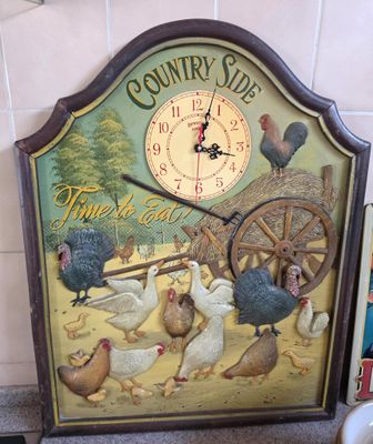 a clock that has a picture of chickens on it