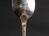 a spoon with a face on it sitting on top of a table
