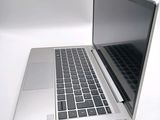 a silver laptop computer sitting on a white surface