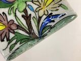 a close up of a tile with flowers and birds on it