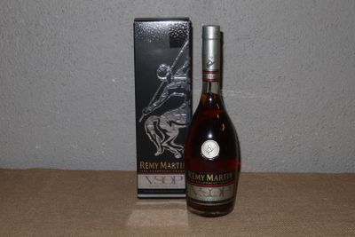 La bouteille de brandy se trouve à côté de la boîte, sur la table.