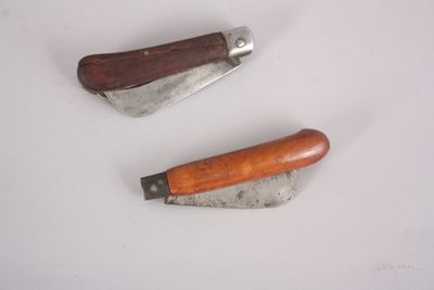 two different types of knives on a white surface
