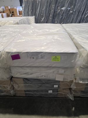 many boxes of mattresses on the floor in a warehouse