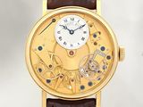 une image d'une montre-bracelet en or avec un bracelet en cuir marron