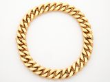 a gold bracelet on a white background