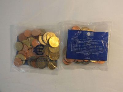 two bags filled with coins sitting on top of a white table