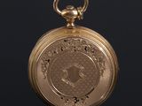 an antique gold pocket watch on a black surface