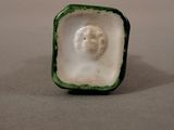 a small ceramic figurine of a man in a square box