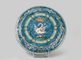 a blue plate with a swan on it and a crown on top
