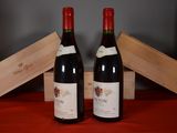 two bottles of red wine sitting next to each other on a table
