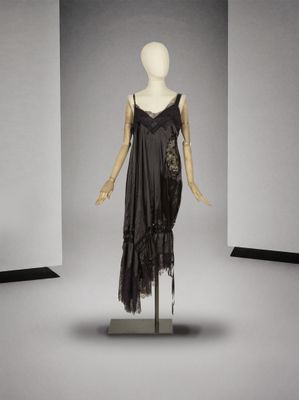 une photo d'un mannequin vêtu d'une robe noire, posé sur un pied