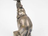 a silver elephant holding a candle on top of a table