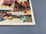 une vieille bande dessinée posée sur une table, avec une souris dessus
