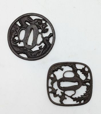 two black iron tsubai with a dragon and a fish design