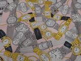 a pink table cloth with a bunch of watches on it