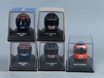 six casques de course miniatures présentés dans des vitrines posées sur une surface blanche