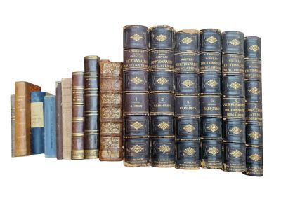 several old books stacked on top of each other on a white surface