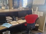 a desk with a red chair and a computer on it