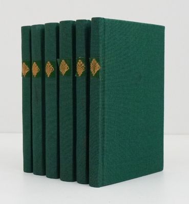 un lot de quatre livres verts ornés de bordures dorées