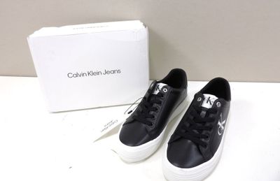 black leather sneakers with white soles and a box on a white surface