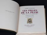 un livre ouvert sur lequel est posée la photo d'un homme coiffé d'un chapeau