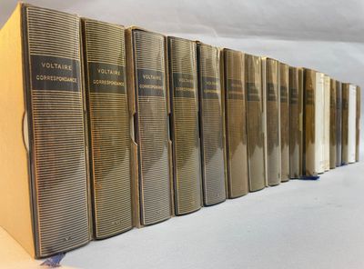 books lined up on a shelf in a row on a white surface