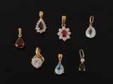 a set of seven gold and gems pendants on a black background