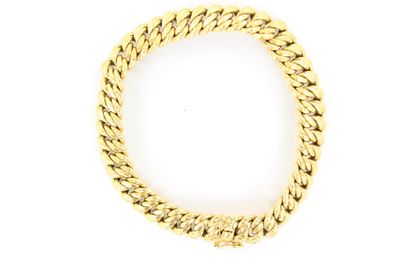 gros plan d'un bracelet en or sur fond blanc