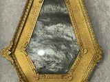gold framed mirror on a gray background
