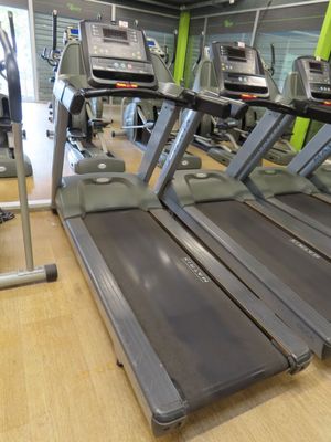 row of treads in a gym room with mirrors on the wall