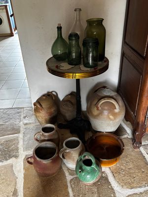 Il y a de nombreux vases et bocaux posés par terre dans cette pièce.