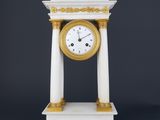 an image of a white and gold clock sitting on top of a table