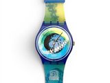 a close up of a watch on a white surface with a blue band