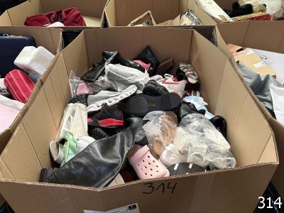 many pairs of shoes in a cardboard box on the floor