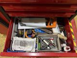 a red tool box filled with assorted tools on the floor