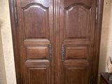 une grande armoire en bois dans le coin d'une pièce