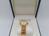 a gold watch in a blue box with a white background