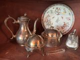 a silver tea pot and a silver teapot on a shelf
