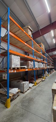 des rayonnages dans un entrepôt, sur lesquels sont posées des palettes et des cartons