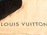 a louis vuitton bag sitting on top of a towel
