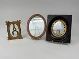 deux petits miroirs et un support de miroir posés sur une surface blanche