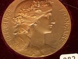 a gold medal in a velvet case with a label on it