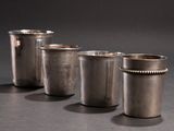 three silver cups are lined up in a row on a black surface