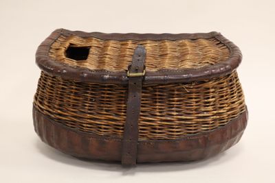 a wicker basket with a leather handle on a white background