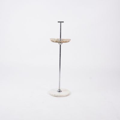 a white marble pedestal with a metal base and a glass bowl on top