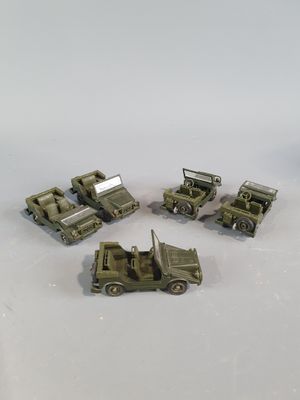 four army vehicles that are sitting on a white surface