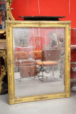a mirror that is sitting on the floor in front of a chair