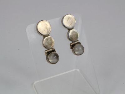 une paire de boucles d'oreilles en argent et labradorite exposées dans une vitrine transparente