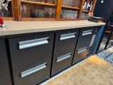 a counter with a bunch of drawers and a lamp on it
